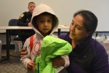 Four-year-old Estevan Saldano shows off new shoes and jacket with mom Araceli. 